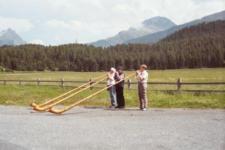 Traditional alpine horn players practicing by the roadside
